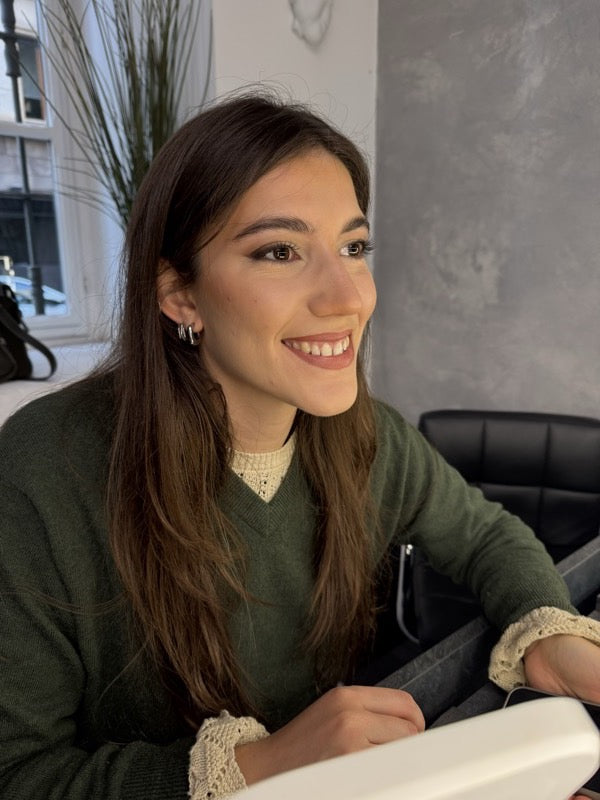 Una ragazza sorridente alla postazione di trucco durante una lezione